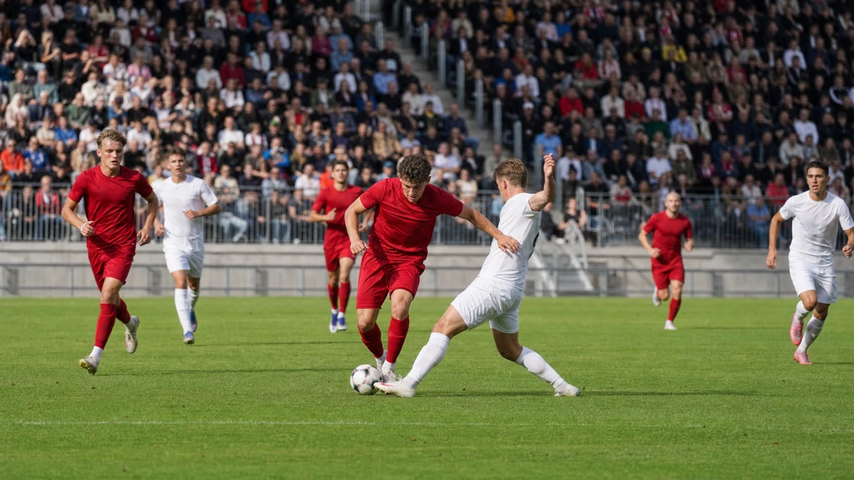 Två spelare i rött och vitt kämpar om bollen i en allsvensk match.